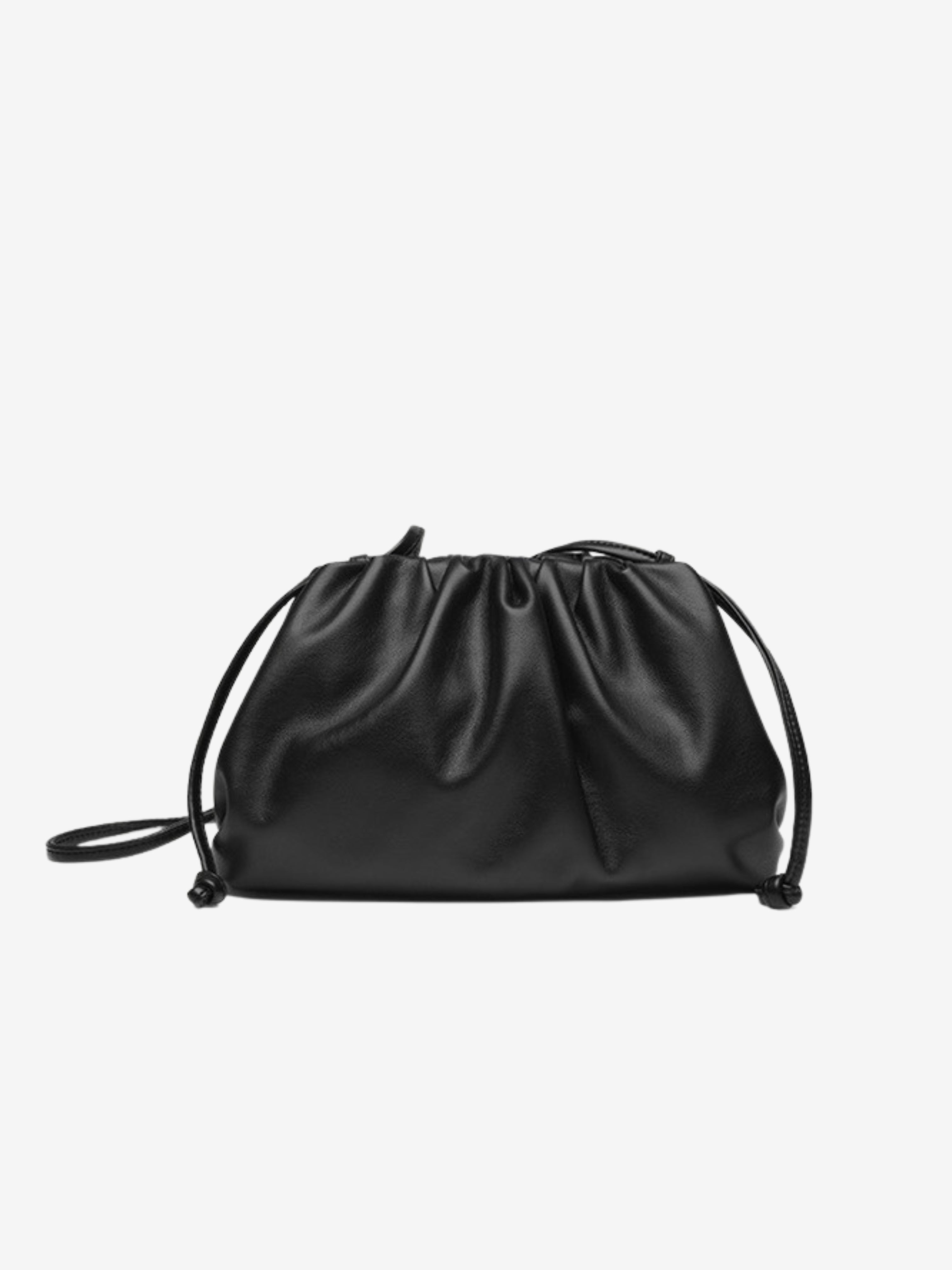 De Serena Zachte Leren Pouch Tas van Liora The Label heeft een minimalistisch ontwerp in zwart boterzacht leer, met een gathered top en dunne schouderband, stijlvol getoond op een witte achtergrond.