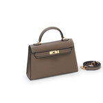 De Liora The Label Aurora Signature Mini Leren Handtas is een bruine gestructureerde handtas met bovenhandgreep en witte stiksels, gouden hardware en wordt geleverd met een afneembare schouderriem.