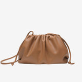 De Serena Zachte Leren Pouch Tas van Liora The Label is een minimalistische, moderne & soepel bruine schoudertas van boterzacht leer met een ontspannen, gerimpeld ontwerp en dunne bandjes, getoond op een witte achtergrond.