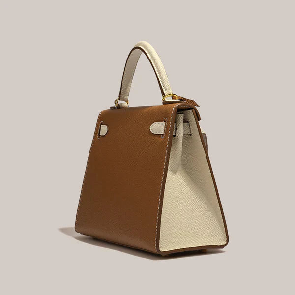 De Jovienne luxe teal & tan leren handtas van Liora The Label combineert iconische elegantie met een tijdloos ontwerp en heeft een stijlvolle tweekleurige look, perfect op een neutrale achtergrond gepresenteerd.