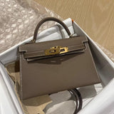 De Galatea, een elegante zwarte leren handtas van Liora The Label, ligt in een open doos met zijdepapier en bubbelplastic; het klassieke ontwerp straalt luxe en functionaliteit uit.