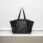 De Caro | Oversized Leren Tote van Liora The Label, met een zachte structuur en twee handgrepen, is afgebeeld op een wit oppervlak met een effen witte achtergrond. Perfect als dagelijkse draagtas.