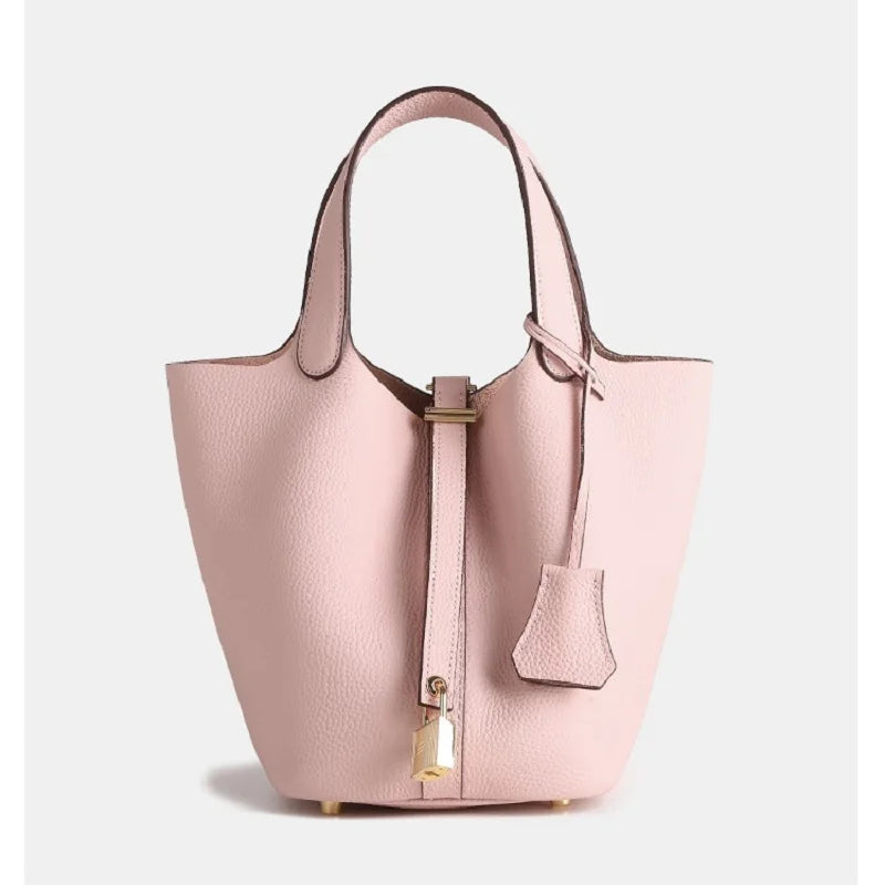 De Elaris | Luxe Taupe Leren Emmer Tas van Liora The Label is een eersteklas tote bag met een gestructureerde vorm, goudkleurige details, glad kiezelleer, hangende slotbedel en kort handvat - elegant en tijdloos in ontwerp.