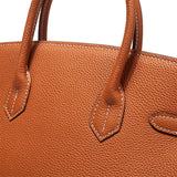 Close-up van de Isla Tan Textured Leather Handtas van Liora The Label, met twee handvatten en zichtbare witte stiksels langs de randen voor een klassiek & tijdloos uiterlijk.