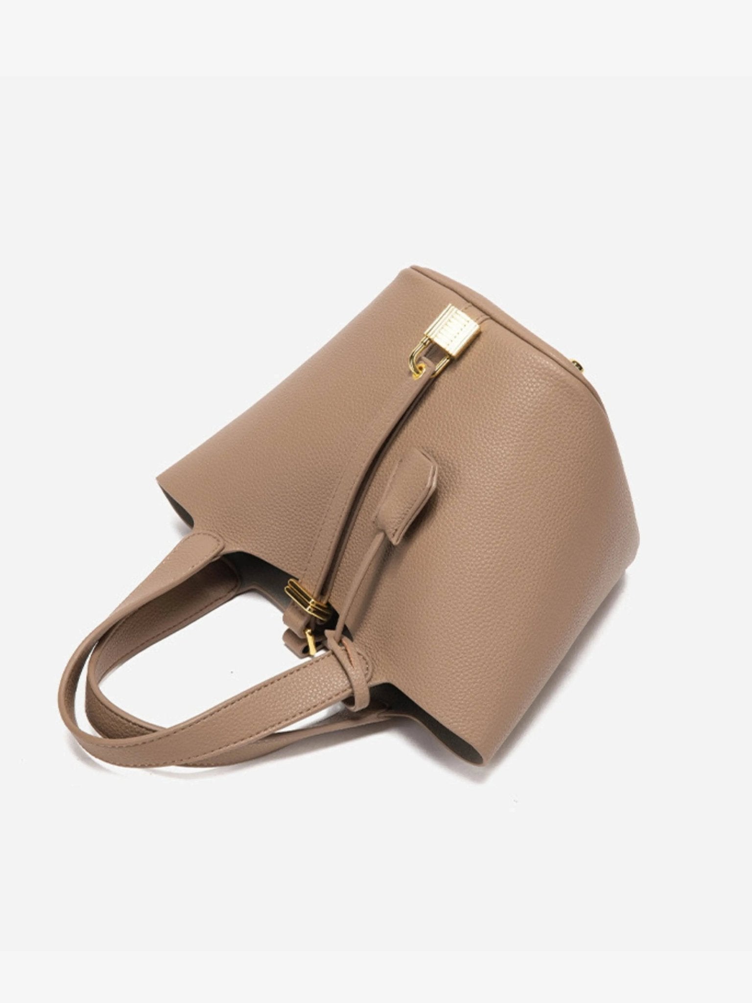 De Elaris Luxe Taupe Leren Emmer Tas van Liora The Label heeft premium structuurleer, gouden hardware, dubbele handgrepen, een gestructureerd ontwerp en een slotdetail aan de voorkant, afgebeeld tegen een witte achtergrond.