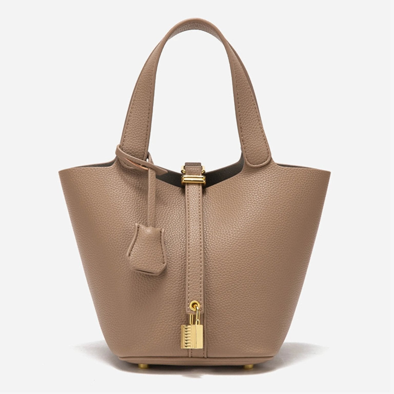 De Elaris Luxe Taupe Leren Emmer Tas van Liora The Label is een tijdloze, elegante bucket bag met gestructureerd leer, dubbele hengsels, een centrale riem met goudkleurig hangslot en een leren sleuteletui - de minimalistische stijl maakt een opvallend statement.