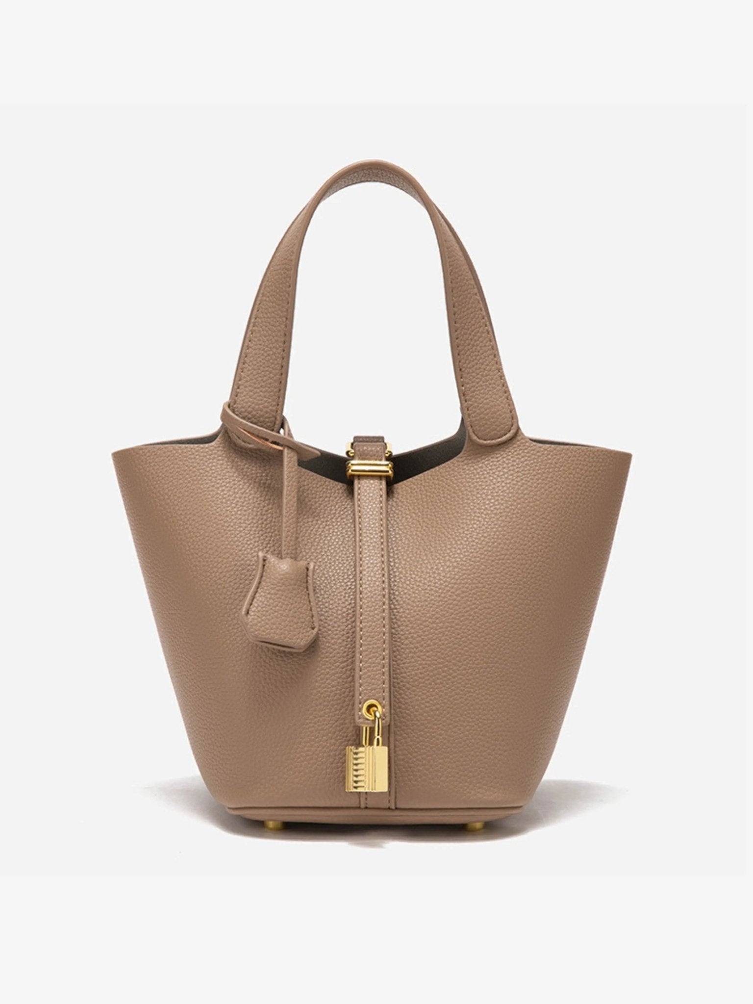 De Elaris Luxe Taupe Leren Emmer Tas van Liora The Label is een tijdloze, elegante bucket bag met gestructureerd leer, dubbele hengsels, een centrale riem met goudkleurig hangslot en een leren sleuteletui - de minimalistische stijl maakt een opvallend statement.