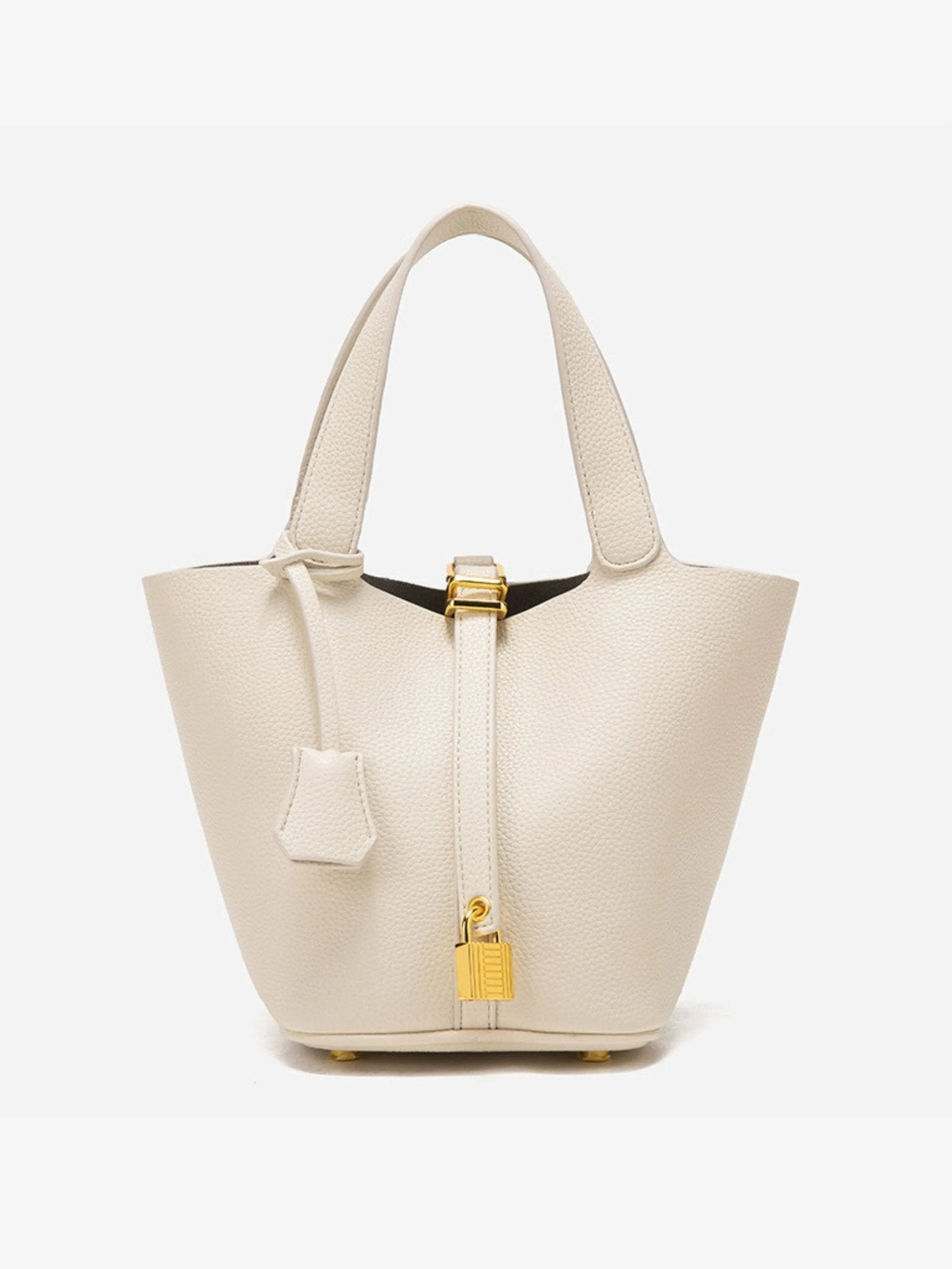 De Elaris Luxe Taupe Leren Emmer Tas van Liora The Label is een eersteklas, crèmekleurige bucket bag met twee bovenhengsels en een gouden hangslotdetail, afgebeeld tegen een effen witte achtergrond.