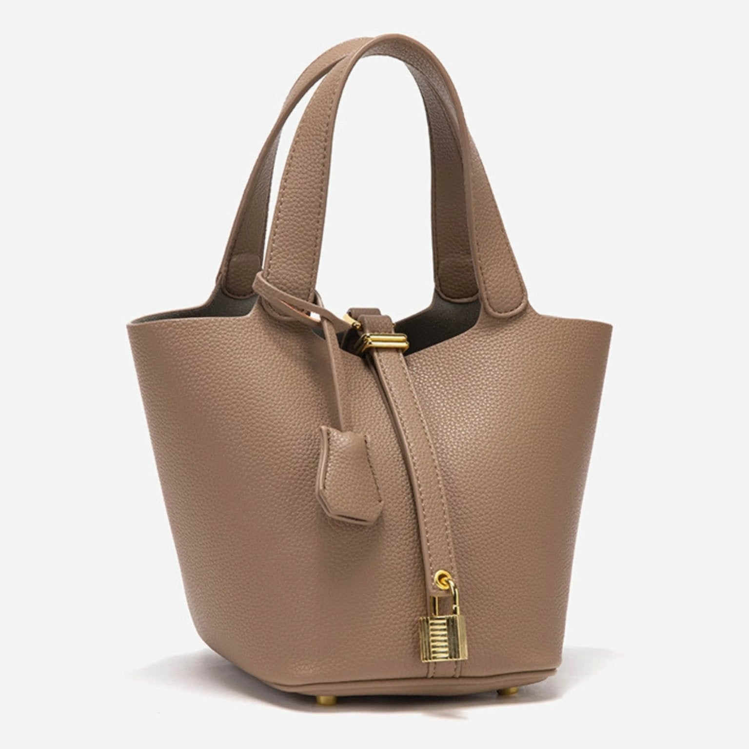 De Elaris | Luxe Taupe Leren Emmer Tas van Liora The Label is een gestructureerde, eersteklas taupe bucket bag met gestructureerd leer, goudkleurige hardware, twee hengsels en een hangslot, die tijdloze elegantie biedt tegen een witte achtergrond.