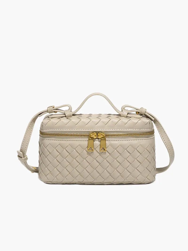 De Luxe Geweven Box Bag van Liora The Label is een kleine, rechthoekige donkerbruine crossbody van veganistisch leer met een gouden rits, dubbele trekkers, handvat aan de bovenkant en verstelbare schouderriem, afgebeeld op een effen witte achtergrond.
