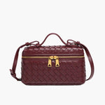 De Luxe Geweven Box Bag van Liora The Label is een elegante donkerbruine crossbody met een gouden ritssluiting, bovenhandgreep en verstelbare schouderriem, afgebeeld op een witte achtergrond.