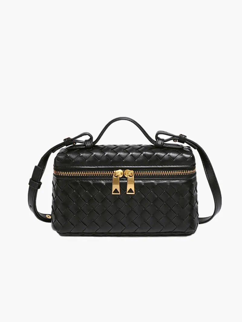 De Luxe Geweven Box Bag van Liora The Label is een donkerbruine crossbody van veganistisch leer met bovenhandvat, verstelbare riem, gouden ritssluiting en piramidevormige trekkers, afgebeeld op een witte achtergrond.