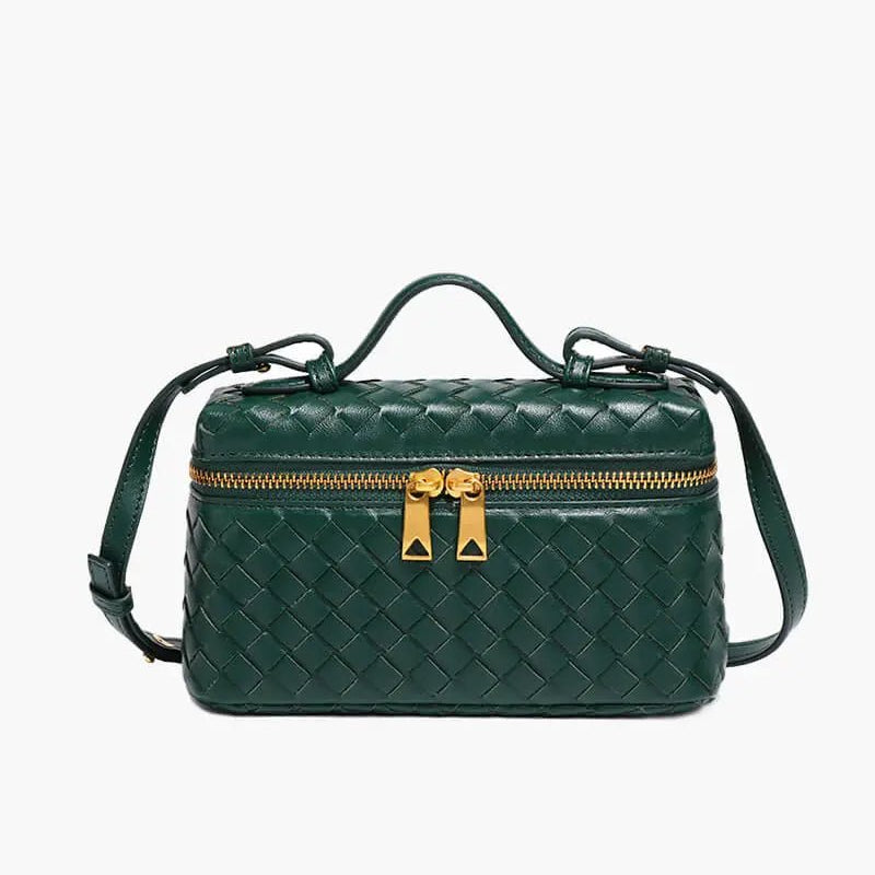 De Luxe Geweven Box Bag van Liora The Label is een elegante, donkerbruine crossbody van veganistisch leer met een handvat aan de bovenkant, een gouden rits met dubbele trekkers en een lange schouderriem, tegen een witte achtergrond.