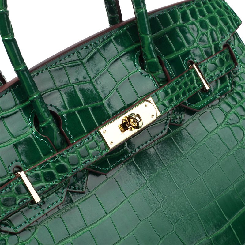 Close-up van de Isla Luxe Smaragdgroene Crocodilleer Geëmbossede Tote Bag van Liora The Label, met goudkleurige hardware, draaisluiting en stevige hengsels. De veganistische leren handtas heeft een glanzende, getextureerde afwerking.